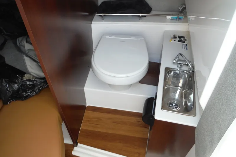 Slide: The Image of Compact bathroom in 2025 Chaparral 310 OSX boat with toilet and sink. - 39