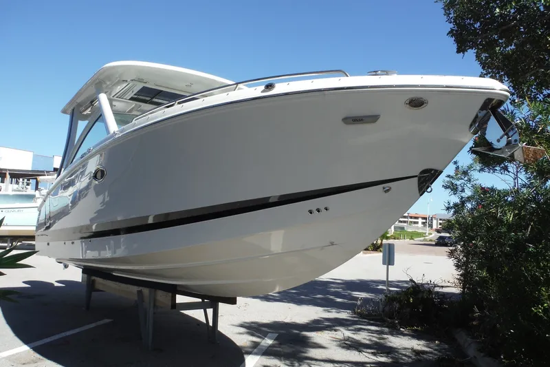 Slide: The Image of 2025 Chaparral 310 OSX boat displayed outdoors on a sunny day. - 23