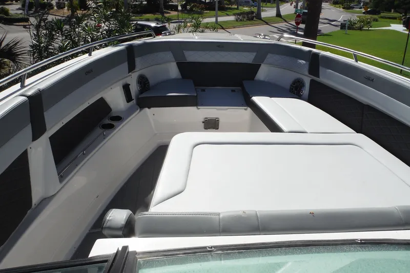 Slide: The Image of 2025 Chaparral 310 OSX boat interior with cushioned seating and cup holders. - 30