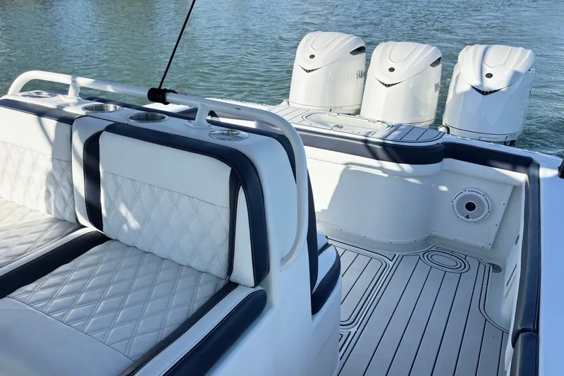 Slide: The Image of 2014 Yellowfin 34 Offshore boat interior with triple outboard engines and cushioned seating. - 15