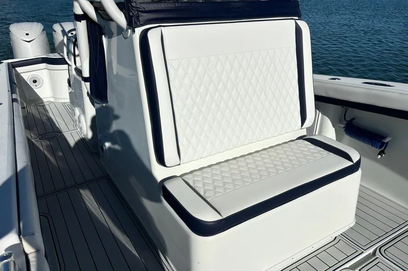 Slide: The Image of 2014 Yellowfin 34 Offshore boat with white cushioned seating and sleek design. - 14