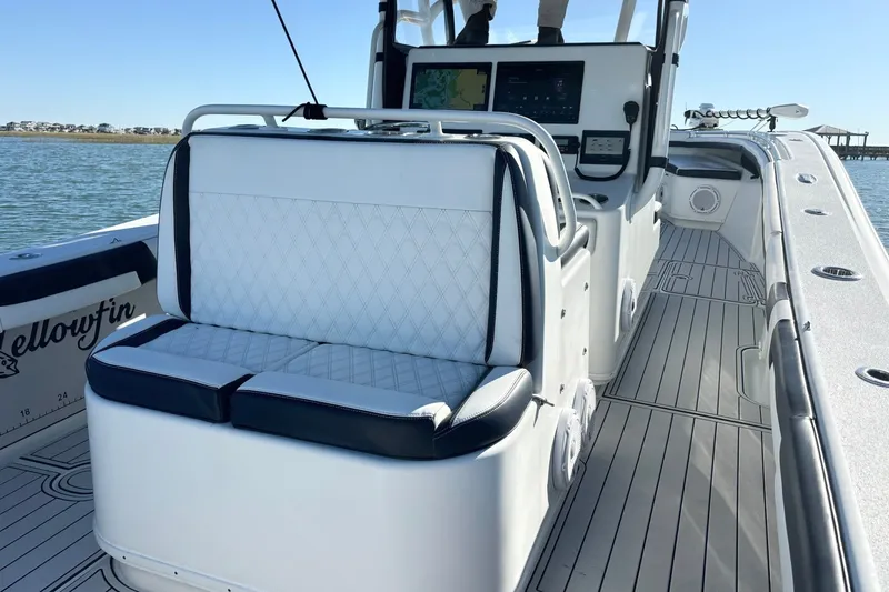 Slide: The Image of 2014 Yellowfin 34 Offshore boat interior with cushioned seating and navigation console. - 16