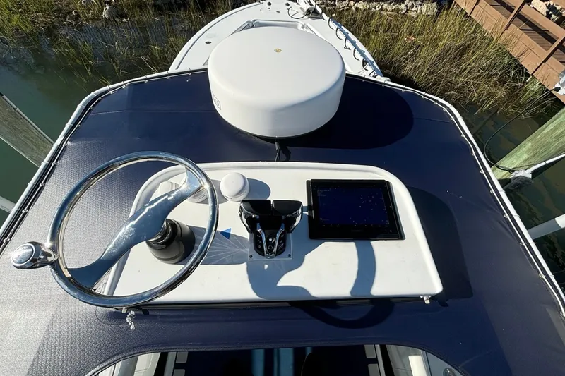 Slide: The Image of 2014 Yellowfin 34 Offshore boat helm with steering wheel and navigation display. - 18