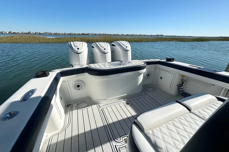 Slide: The Image of 2014 Yellowfin 34 Offshore boat interior with triple engines on calm water. - 17