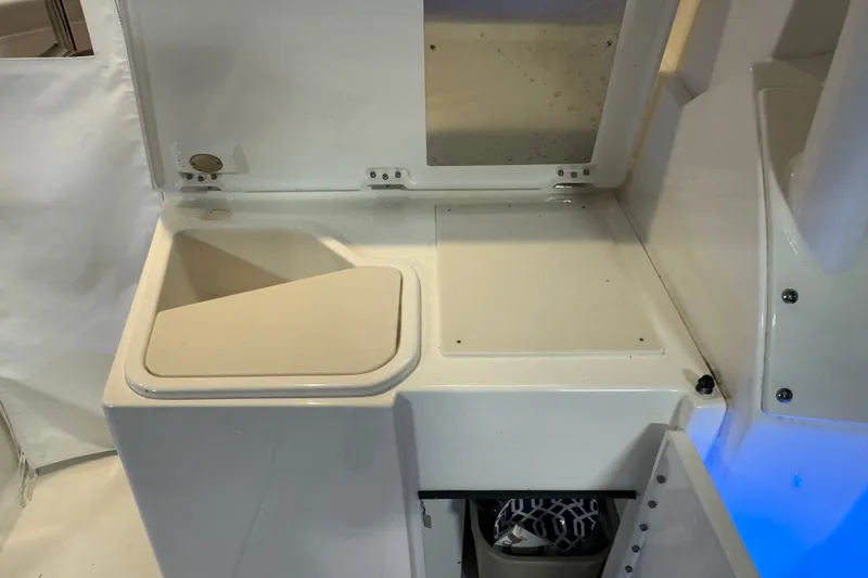 Slide: The Image of 2026 Pursuit DC 326 Dual Console interior detail with storage compartment and sink. - 12