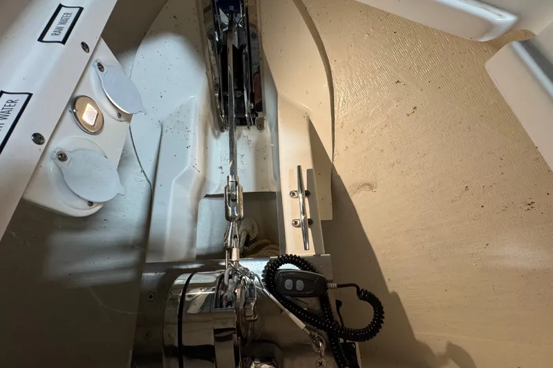 Slide: The Image of Anchor compartment of 2026 Pursuit DC 326 Dual Console boat, featuring winch and controls. - 34