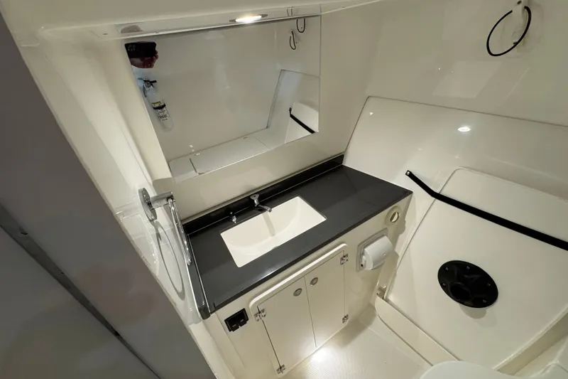 Slide: The Image of 2026 Pursuit DC 326 Dual Console boat bathroom with sleek sink and mirror. - 31