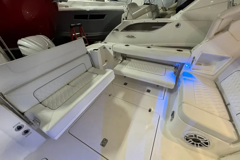 Slide: The Image of 2026 Pursuit DC 326 Dual Console boat interior with white seating and blue accent lighting. - 8