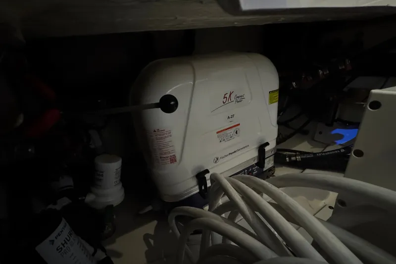 Slide: The Image of Engine compartment of 2026 Pursuit DC 326 Dual Console with generator and cables. - 17