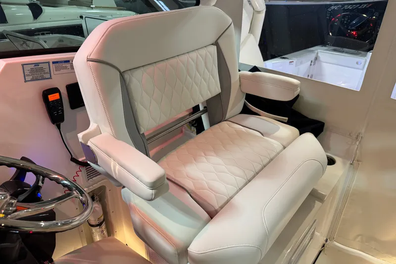 Slide: The Image of Captain's seat in 2026 Pursuit DC 326 Dual Console boat, featuring luxurious white upholstery. - 24