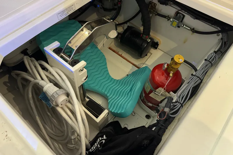 Slide: The Image of Storage compartment of 2026 Pursuit DC 326 Dual Console with equipment and fire extinguisher. - 15