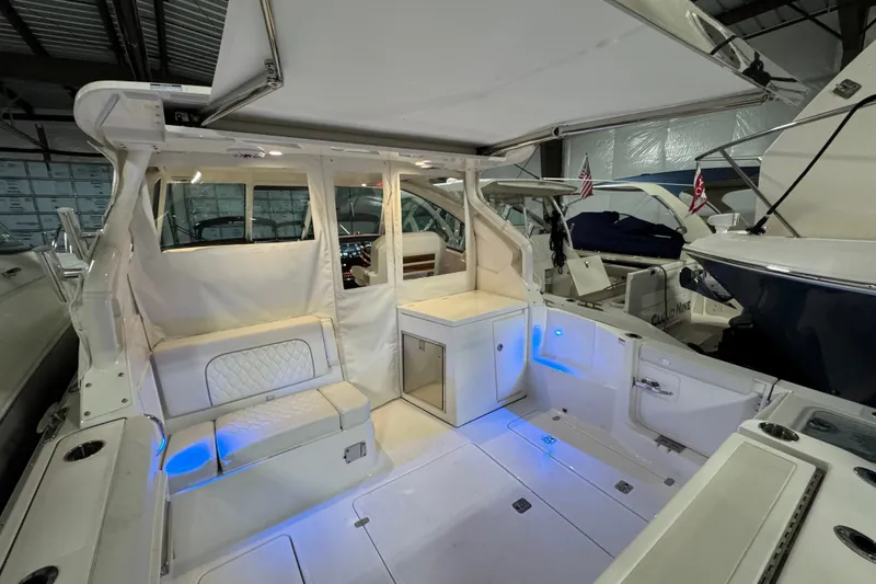 Slide: The Image of 2026 Pursuit DC 326 Dual Console boat interior with seating and ambient lighting. - 7