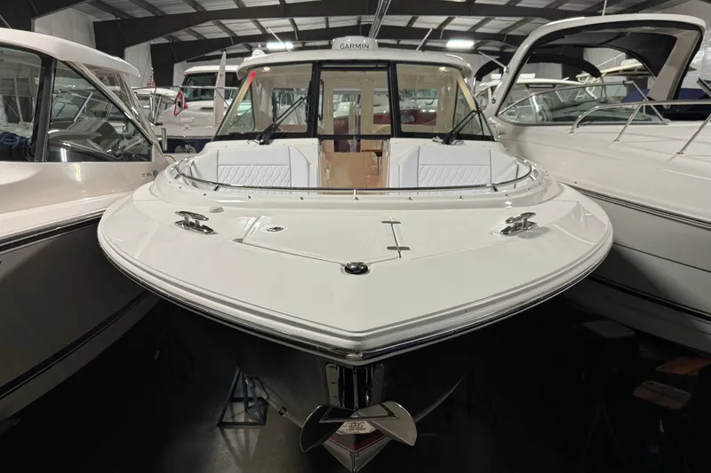 Slide: The Image of 2026 Pursuit DC 326 Dual Console boat displayed in a showroom. - 3