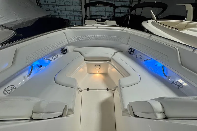 Slide: The Image of 2026 Pursuit DC 326 Dual Console boat interior with blue LED lighting and white seating. - 32