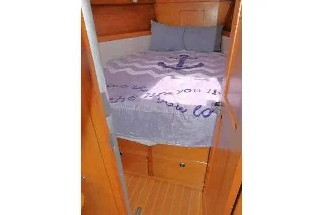 Slide: The Image of Cozy cabin interior of 2001 Catalina 310 sailboat with nautical-themed bedding. - 16