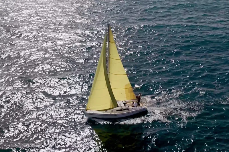 Slide: The Image of Sailboat Catalina 310 (2001) with yellow sails gliding on sparkling blue ocean. - 18