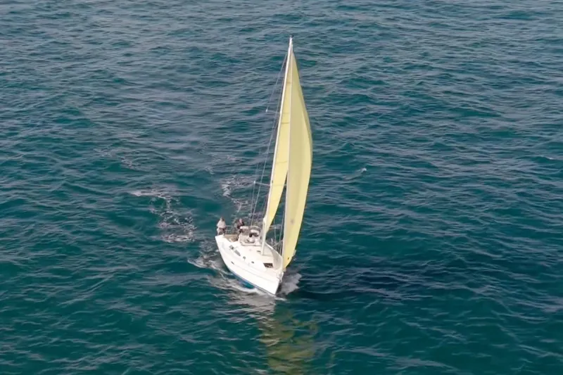 Slide: The Image of Sailboat Catalina 310 (2001) with yellow sail navigating open sea. - 19