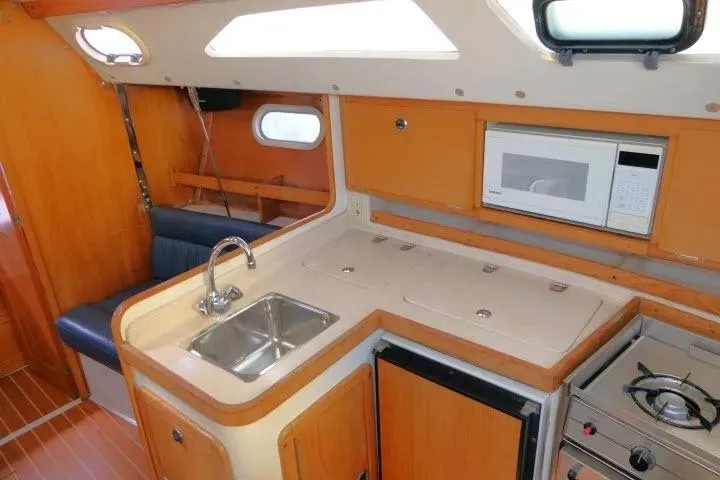 Slide: The Image of Interior of a 2001 Catalina 310 sailboat kitchen with sink, stove, and microwave. - 13