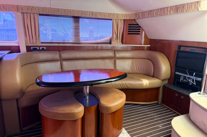 Slide: The Image of Interior of 2005 Sea Ray 390 Motor Yacht with leather seating and wooden table. - 17