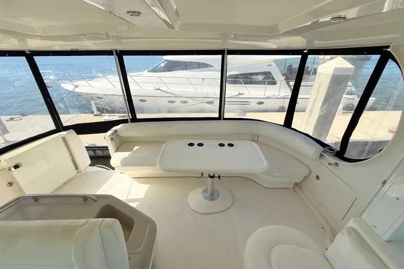 Slide: The Image of 2005 Sea Ray 390 Motor Yacht interior with seating and table, overlooking marina. - 10