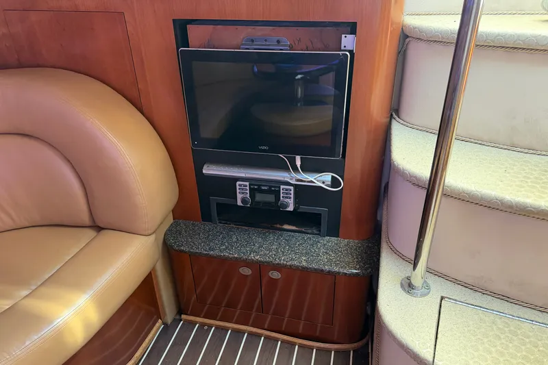 Slide: The Image of 2005 Sea Ray 390 Motor Yacht interior with TV, leather seating, and staircase. - 18