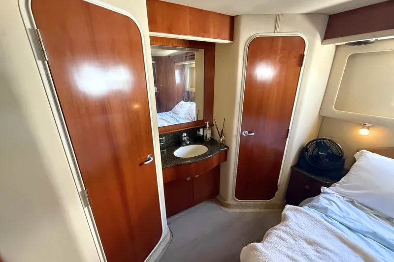 Slide: The Image of Luxurious 2005 Sea Ray 390 Motor Yacht interior with wood accents and cozy bedroom. - 26