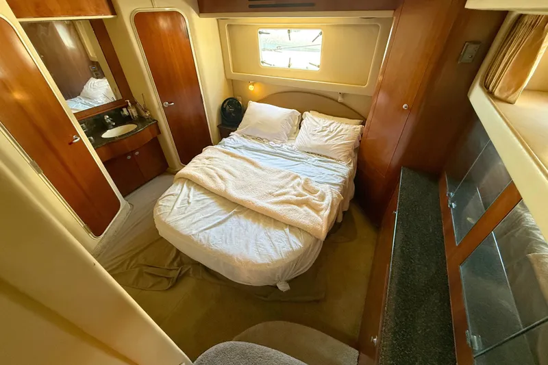 Slide: The Image of Luxurious bedroom interior of 2005 Sea Ray 390 Motor Yacht with cozy bed and wooden cabinetry. - 24