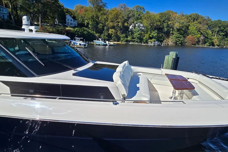 Slide: The Image of 2026 Tiara Yachts 56 LS luxury yacht docked by a scenic waterfront. - 25