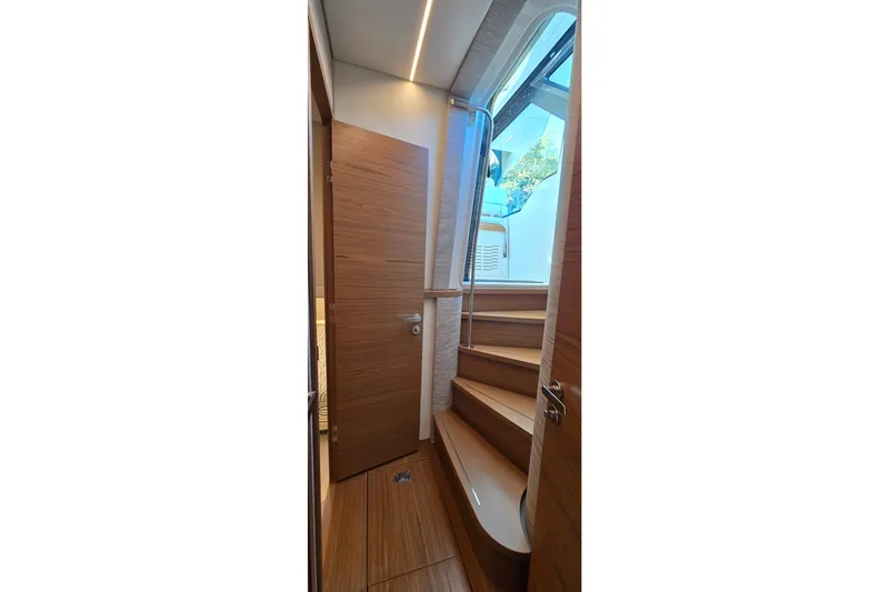Slide: The Image of Interior staircase of 2026 Tiara Yachts 56 LS, featuring wooden steps and modern design. - 55