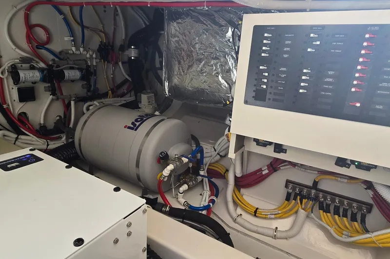 Slide: The Image of Engine room of 2026 Tiara Yachts 56 LS, featuring electrical panel and equipment. - 80