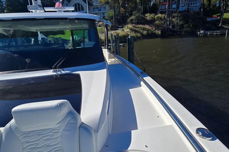 Slide: The Image of 2026 Tiara Yachts 56 LS luxury boat docked by a scenic waterfront. - 36