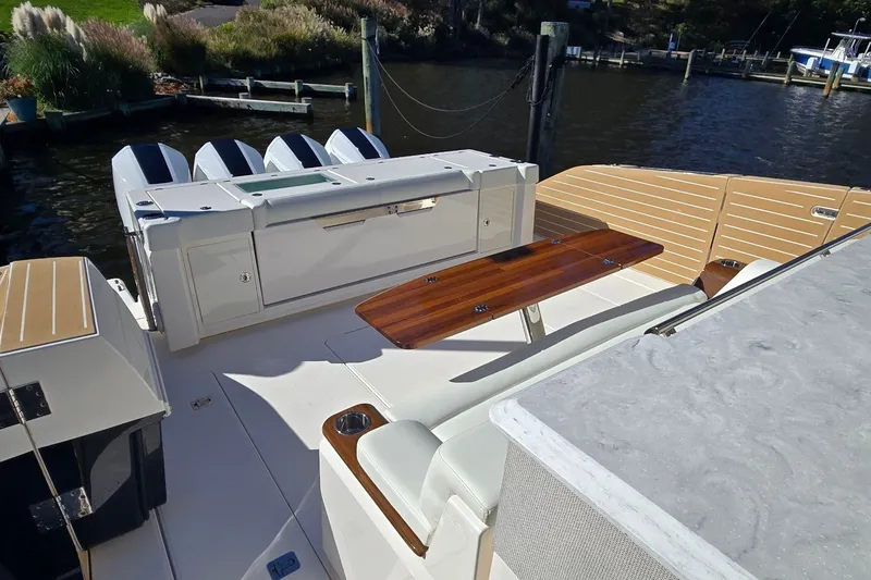 Slide: The Image of 2026 Tiara Yachts 56 LS luxury boat deck with seating and table, docked by the water. - 21