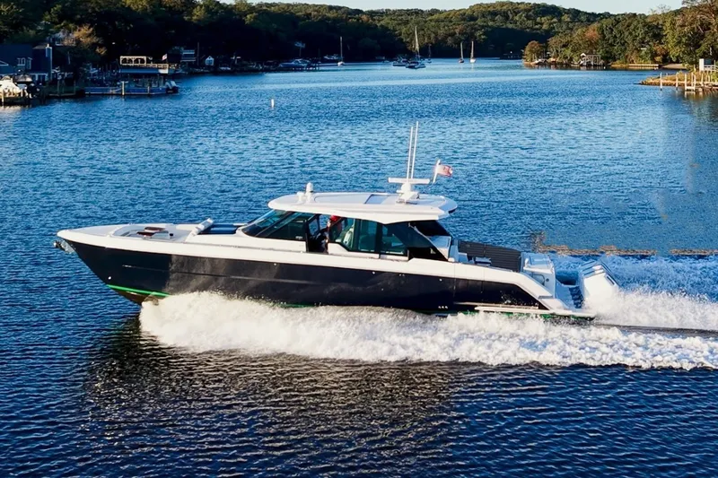 Slide: The Image of 2026 Tiara Yachts 56 LS cruising on a serene lake with wooded shoreline. - 5
