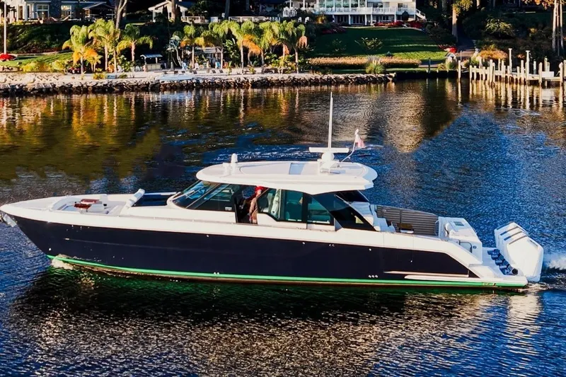 Slide: The Image of 2026 Tiara Yachts 56 LS cruising on a scenic waterfront with lush greenery. - 3