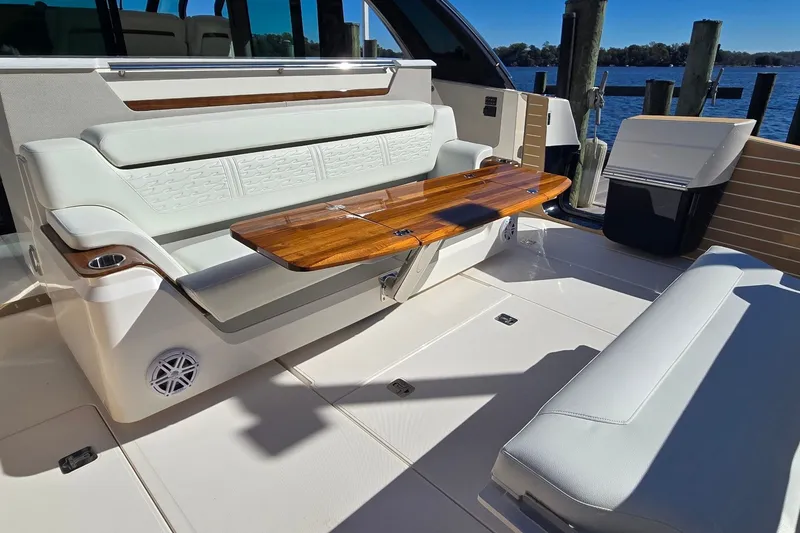 Slide: The Image of Luxurious seating area on 2026 Tiara Yachts 56 LS, featuring elegant wood table and plush cushions. - 18