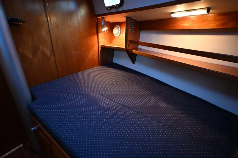 Slide: The Image of Cozy cabin interior of 2001 Caliber 40 LRC yacht with wooden shelves and blue bedding. - 55