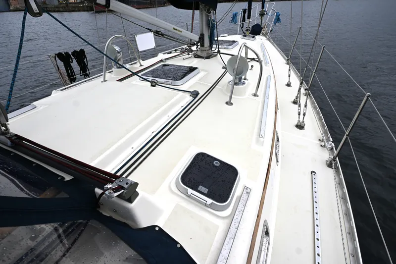 Slide: The Image of 2001 Caliber 40 LRC sailboat deck with hatches and rigging, docked on calm water. - 5