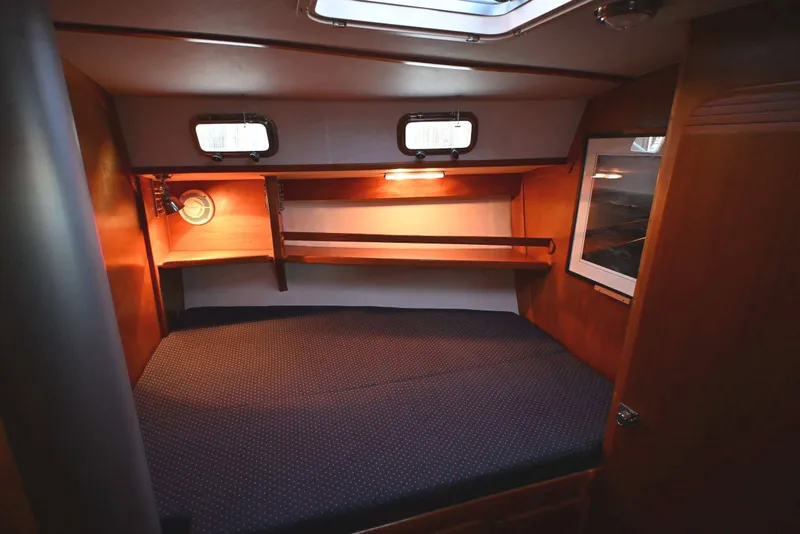 Slide: The Image of Cozy cabin interior of 2001 Caliber 40 LRC sailboat with wooden shelves and bedding. - 56