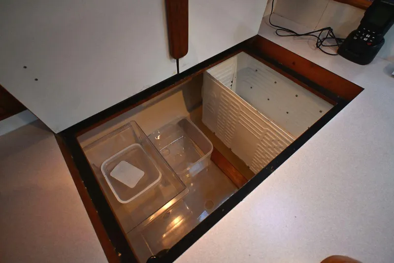 Slide: The Image of Storage compartment in a 2001 Caliber 40 LRC boat, featuring organized containers. - 48