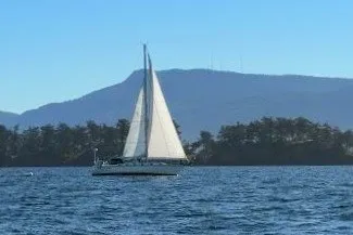 Slide: The Image of Sailboat Caliber 40 LRC 2001 on open water with mountainous backdrop. - 1