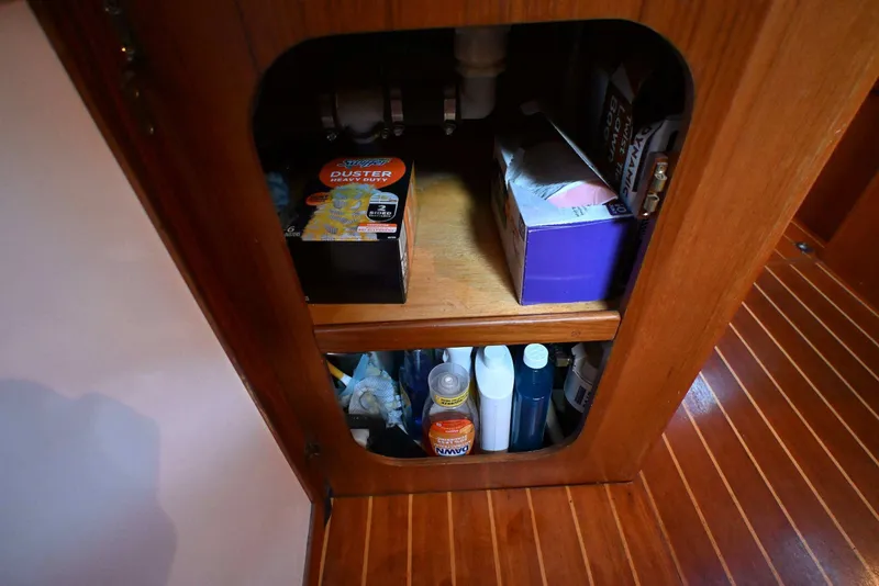 Slide: The Image of Wooden cabinet storage with cleaning supplies on a 2001 Caliber 40 LRC boat. - 67
