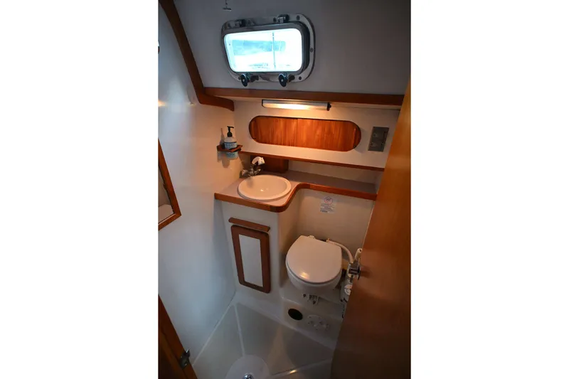 Slide: The Image of Compact bathroom in 2001 Caliber 40 LRC yacht with sink, toilet, and porthole. - 63