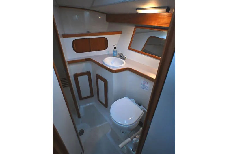 Slide: The Image of 2001 Caliber 40 LRC yacht bathroom with sink, toilet, and wooden accents. - 60