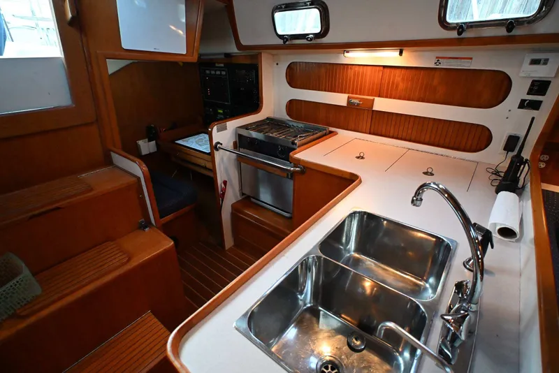Slide: The Image of Interior of 2001 Caliber 40 LRC yacht featuring kitchen with sink, stove, and wooden cabinetry. - 46