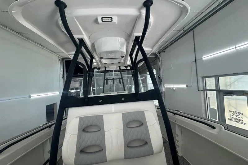 Slide: The Image of 2020 Twin Vee 260 CC SE boat interior with seating and canopy in a garage. - 36