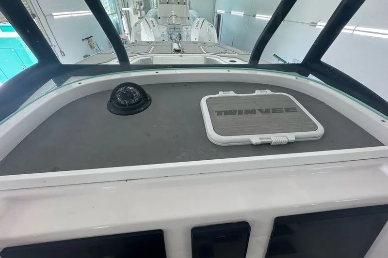 Slide: The Image of 2020 Twin Vee 260 CC SE boat dashboard with compass and branded hatch. - 34