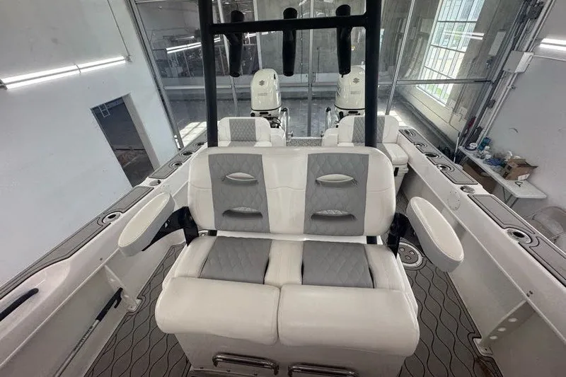 Slide: The Image of 2020 Twin Vee 260 CC SE boat interior with cushioned seating and dual outboard motors. - 44