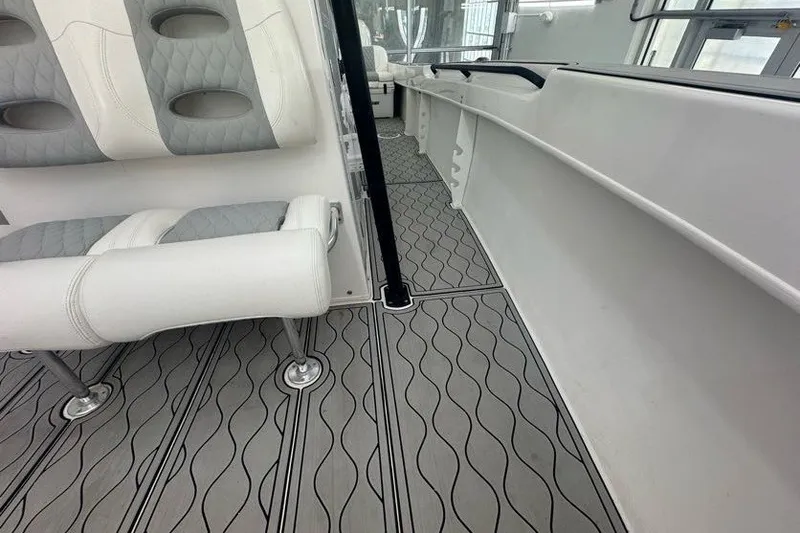 Slide: The Image of 2020 Twin Vee 260 CC SE boat interior with gray patterned flooring and white seating. - 47