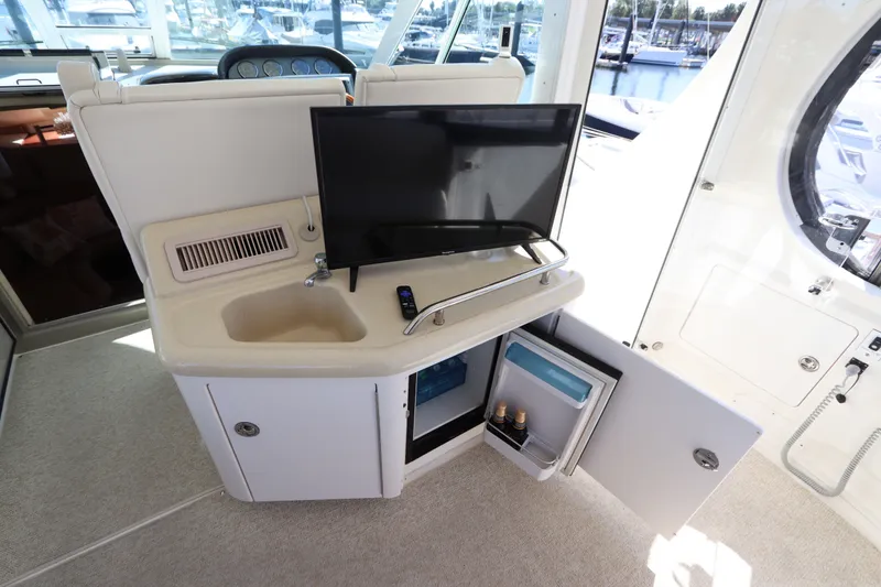 Slide: The Image of 2005 Sea Ray 390 Motor Yacht interior with sink, TV, and open storage cabinet. - 18