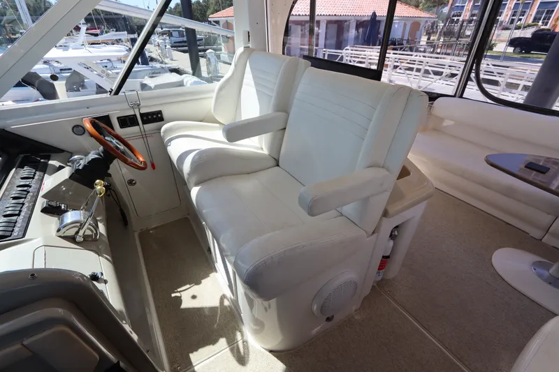 Slide: The Image of 2005 Sea Ray 390 Motor Yacht helm with white seating and control panel. - 23